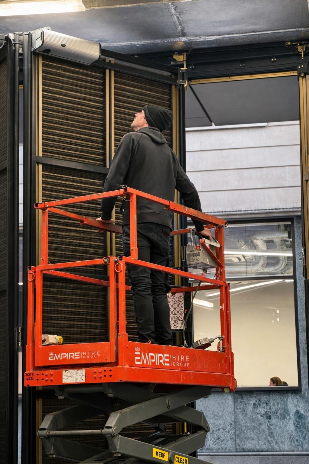 Engineer servicing a high level door operator from a scissor lift